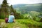 Tourist exploring the woodlands of Wicklow Mountains National Park. Old pine trees and lush greenery of Glendalough valley, County