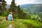 Tourist exploring the woodlands of Wicklow Mountains National Park. Old pine trees and lush greenery of Glendalough valley, County