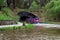 A tourist ferry boat enters a tunnel from Falkirk Wheel boat lift to Union Canal locks on the other side, Scotland