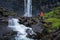 Tourist at the Fossa Waterfall on island Bordoy in the Faroe Islands