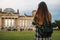 A tourist girl with a backpack next to the building called the Reichstag in Berlin in Germany takes pictures