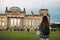 A tourist girl with a backpack next to the building called the Reichstag in Berlin in Germany takes pictures