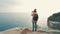 Tourist girl with a backpack standing on the edge of a cliff and shooting photo