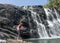 Tourist girl carefully walking near the Baker`s falls