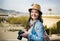 Tourist girl in denim shirt with camera, sunny city