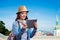 Tourist girl in denim shirt with tablet. Summer city.