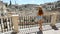 Tourist girl enjoys the stunning view of the Sassi di Matera in Italy on a warm summer day. Slow motion.