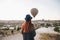 A tourist girl in a hat admires hot air balloons flying in the sky over Cappadocia in Turkey. Impressive sight.