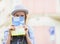 Tourist girl hiding behind map while standing on city street