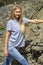 A tourist girl with long white hair climbs the rocks