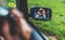 Tourist girl in an open window of a car taking photography click on retro vintage photo camera, photographer looking on reflection