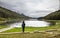 A tourist girl standing next to Lake Engolasters, during a hike, in the Encamp parish of Andorra,. Lake formed in a glacial