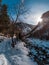 Tourist girl standing on rock near stream that comes from Chalaadi Glacier in winter