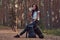 Tourist girl stopped to rest and drink water in the beautiful autumn forest.