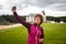 The tourist girl takes a photo of herself on an outstretched hand on a mobile phone on the front camera in France against the back