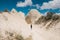 A tourist girl walks along the road next to the wonderful hills of Cappadocia in Turkey and admires the beauty around