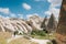 A tourist girl walks along the road next to the wonderful hills of Cappadocia in Turkey and admires the beauty around