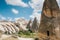 A tourist girl walks along the road next to the wonderful hills of Cappadocia in Turkey and admires the beauty around