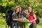 Tourist girls at forest with map and backpacks