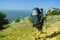 Tourist goes on a mountain range along the sea. The traveler on the background of the blue sky and rocks goes Hiking