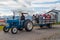 Tourist guide driving a tractor pulling a wagon with tourists