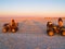 Tourist and guide on quad bikes stop while crossing Makgadikgadi Pans National Park, scenic large flat area of salt pan desert t