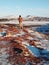 A tourist guy walks near Kerid lake in winter in Iceland. Incredible winter landscape of Iceland