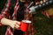 Tourist hands pour coffee from a thermos into a metal red cup