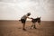 Tourist having fun close to a Donkey in Sahara desert.