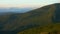 Tourist hiker with a backpack walking on mountain path in Carpathian mountains. Man tourist hiking on rocky desert terrain.