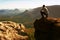 Tourist hiker man on the rock peak in rocky mountains