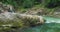 Tourist hiker walks along rocky river bank with clear water. Woman travels in Dark Gorge Lammer Klamm Austria.