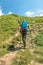 Tourist with hiking backpack walk along a mountain trail. Background illustrating a healthy lifestyle