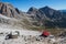 Tourist with hiking backpacks in mountain hike on summer day. Man traveler hiking in beautiful mountain landscape.