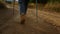 Tourist in hiking boots walking on dirt road. Woman trekking in mountains