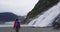 Tourist hiking woman hiker in Alaska walking by glacier and waterfall