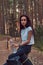 Tourist hipster girl holds a bottle of water, stopped to rest in a beautiful autumn forest.