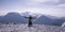 Tourist on his knees in front of a panorama of frozen mountains