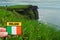 Tourist holding badge with sign Ireland and Irish flag in focus, Cliff of Moher out of focus. Concept travel memory and experience