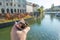 Tourist holding a portion of chestnuts in a cone with river view.