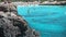 Tourist jumping over the cliff to the turquoise sea water in cala Bosc, Menorca, Spain.