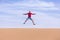 Tourist jumps on dune of Wadi Araba desert, Jordan