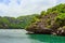 Tourist kayaking in blue Idyllic turquoise ocean to explore near the island with lush green jungle trees and lime stone mountains