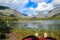 A tourist lies visible body and legs on the ground resting from heavy trekking overlooking the lake in the mountains Khibiny, Ru