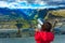 Tourist looking through binoculars in mountains, Norway