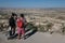 Tourist looking through coin operated binoculars sightseeing scenic, Uchair, castle, Cappadocia, Turkey