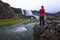 Tourist looking at the Oxarafoss waterfall in Iceland