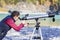 Tourist looks into distance through telescope at mountain river background in mountains