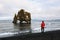 Tourist looks at the Hvitserkur basalt stack in northern Iceland