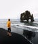 Tourist looks at the Hvitserkur basalt stack in northern Iceland